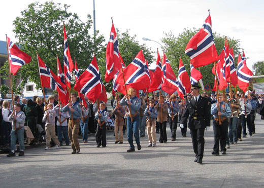 Scouts lead a parade on the 17th of May, Norway's constitution day, holding Norwegian flags.
